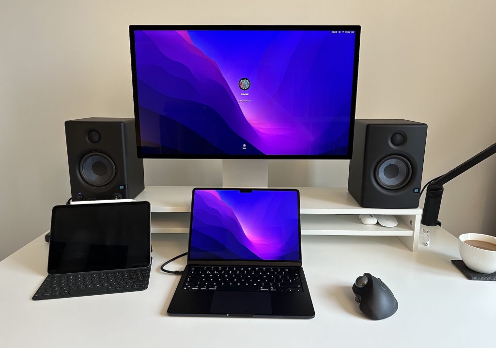 My desk with a Studio Display, monitor speakers, a MacBook, an iPad and a cup of tea.